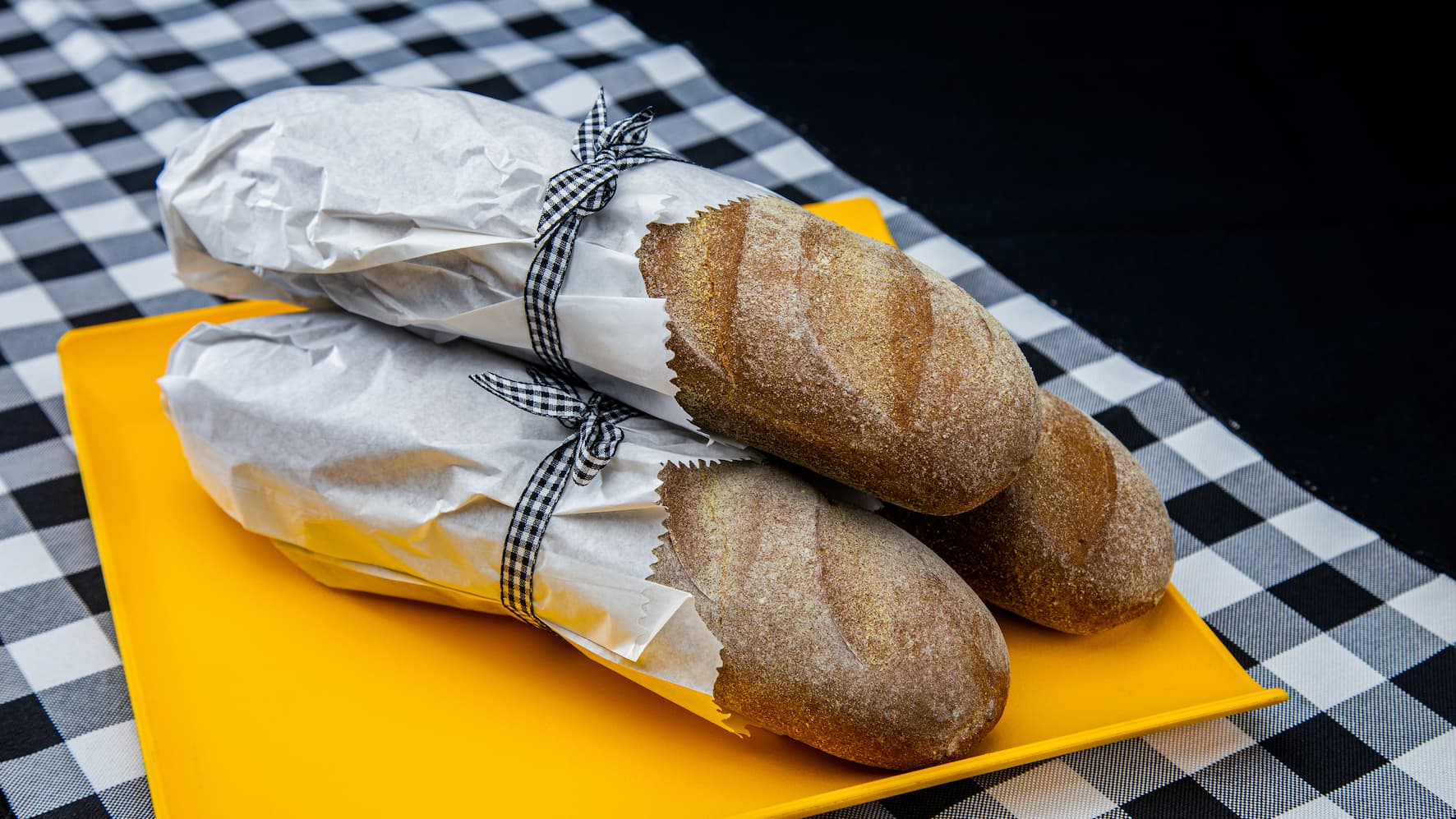 Pães sobre um cesto ao lado de uma xícara de café