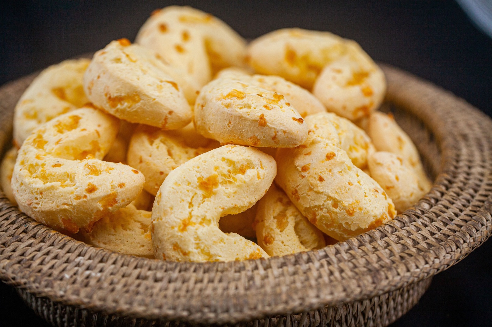 Pães sobre um cesto ao lado de uma xícara de café