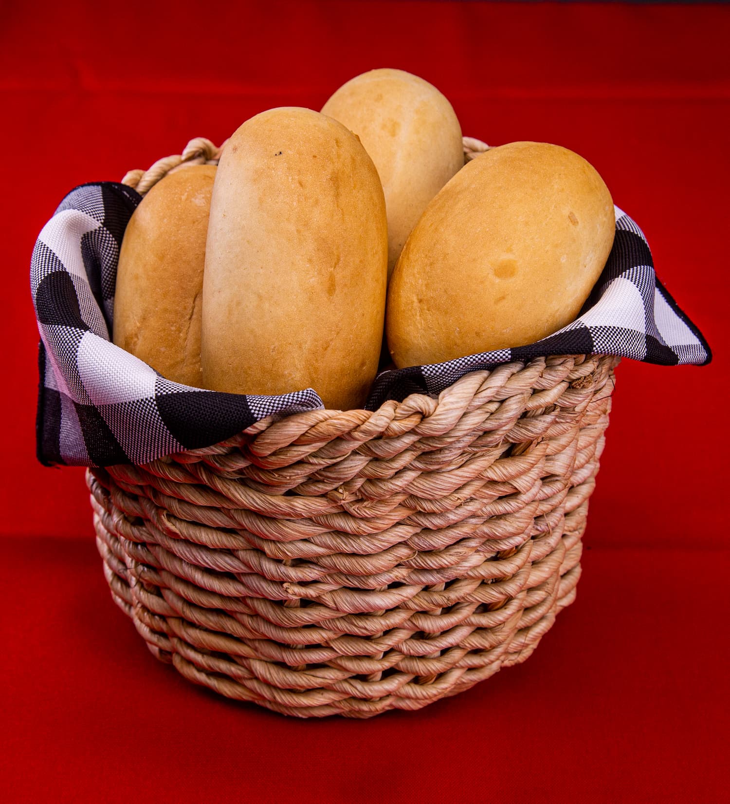 Pães sobre um cesto ao lado de uma xícara de café